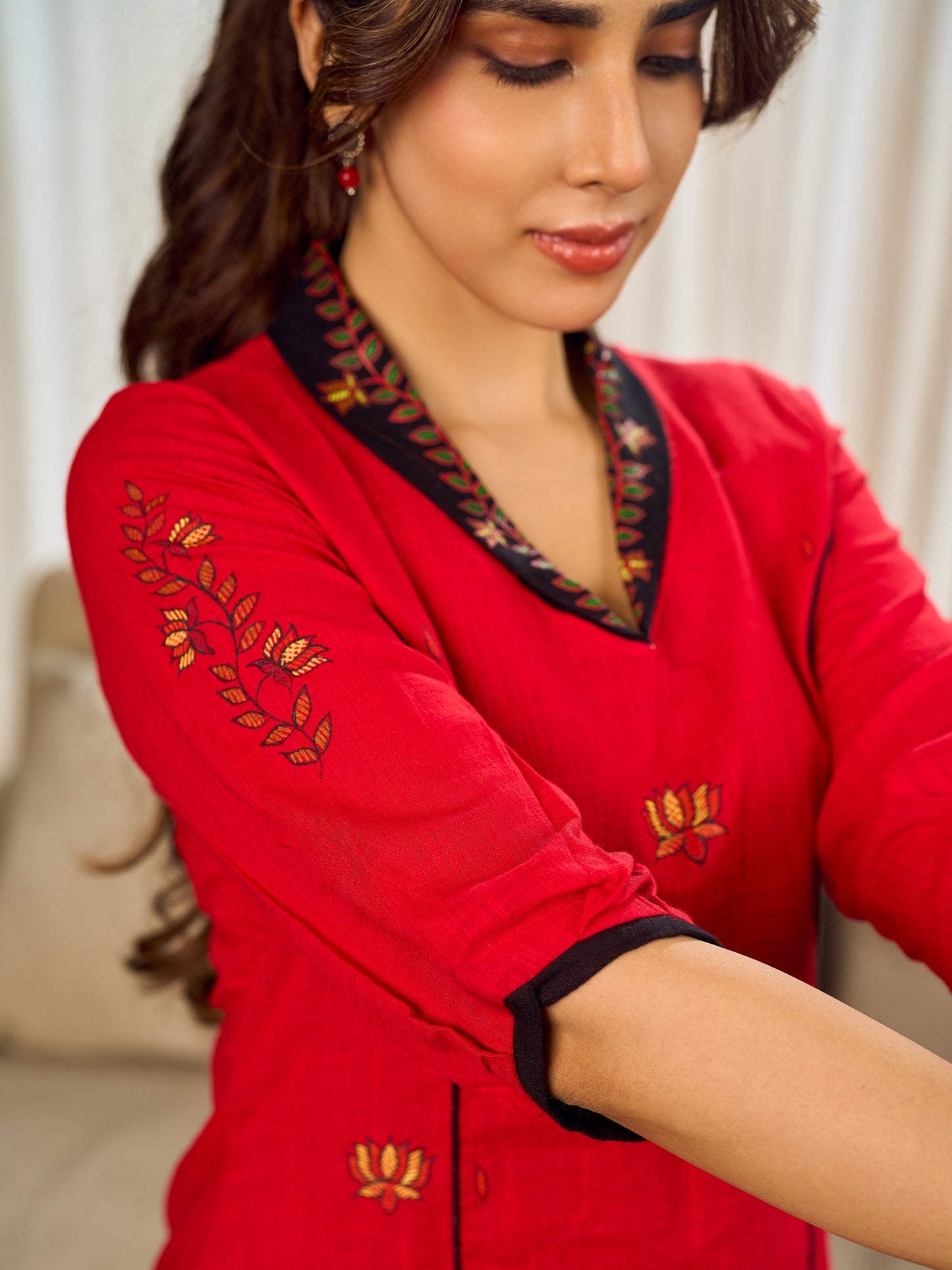 Elegant red dress featuring delicate, hand-painted Madhubani lotus motif detailing.