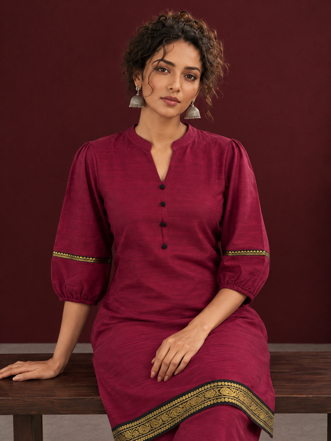 Elegant Maroon Silk Co-Ord Set with Contrast Black & Gold Border Detailing on Hem and Sleeves — seated detail — view 6