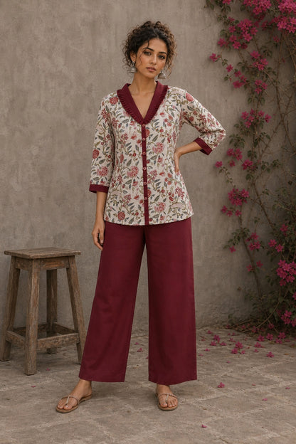 Soft white floral cotton top finished with maroon cuffs, pleated collar, and delicate feminine elegance.