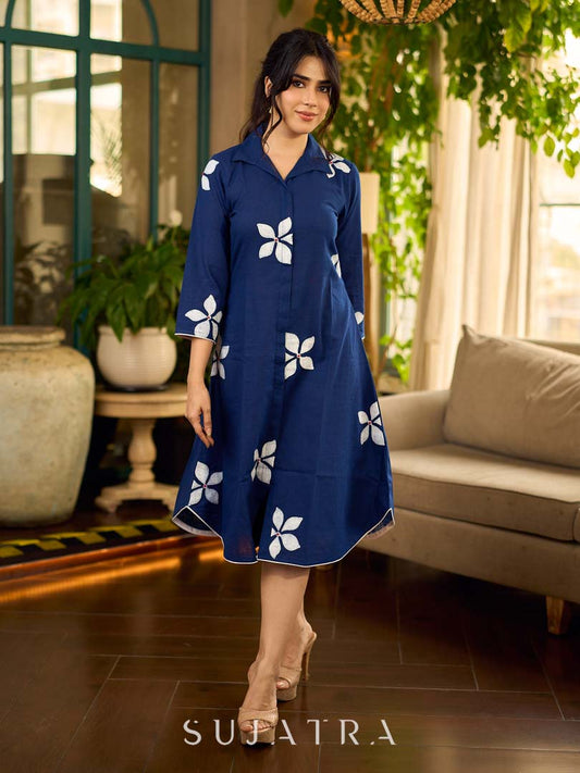 Navy blue apple-cut shirt dress with white floral hand block motifs, conceptually placed and finished with clean white edging and red accents for a refined, contemporary look.