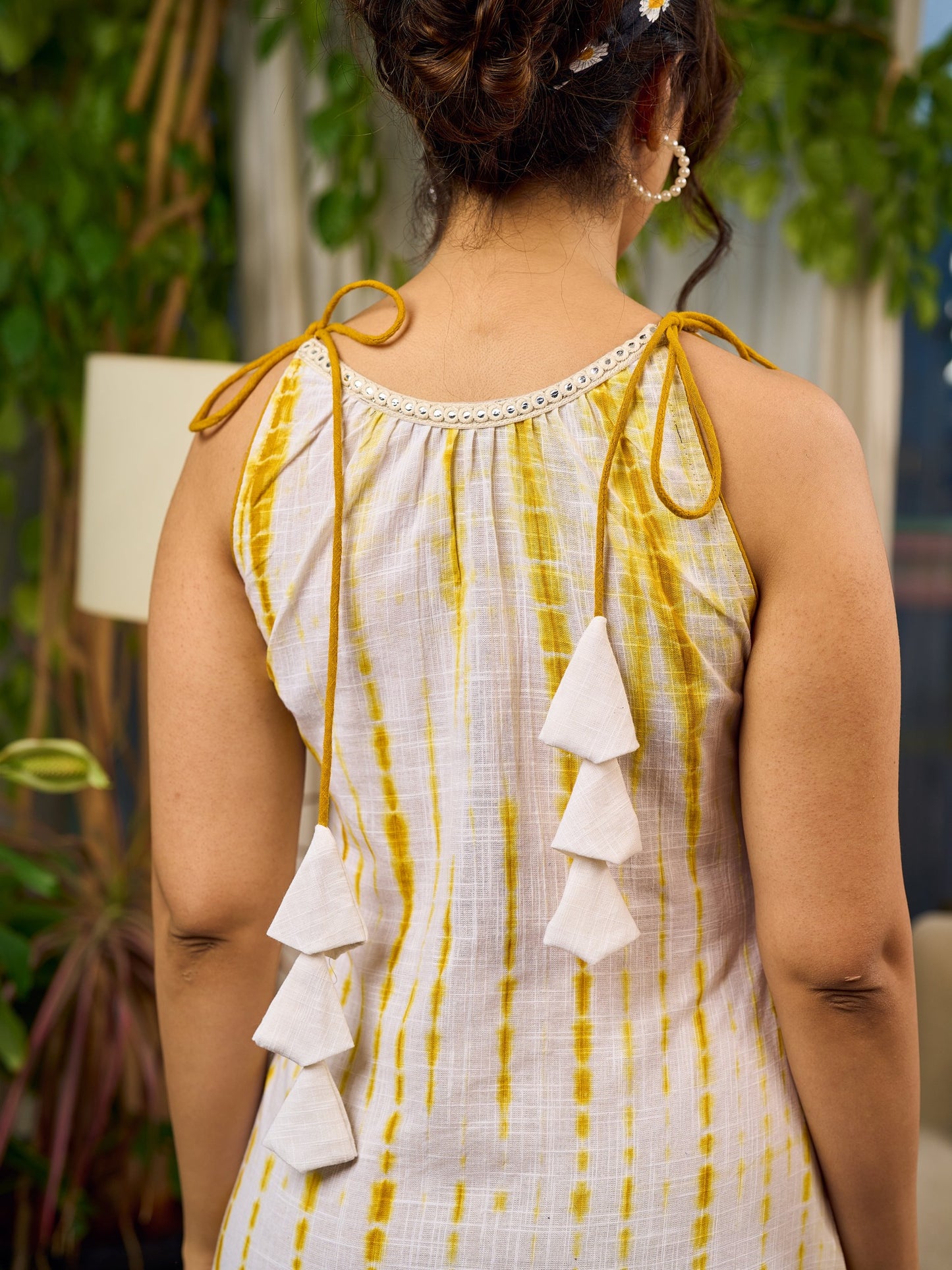 Sunlit ivory tie-dye dress with mustard accents and playful tassel shoulder detailing.