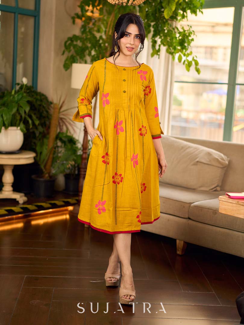 Mustard block printed pintuck dress with hand block red and pink vine floral motifs, accented with red and olive details for a rich, elegant look.