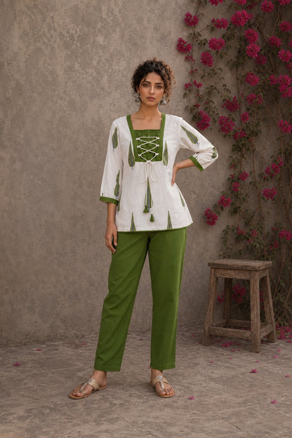 Pretty white Jaipur floral top featuring green leaf motifs, intricate pin-tuck neck, and feminine tie-lace details.