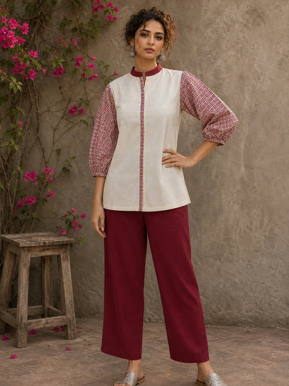 Chic off-white top featuring intricate hand block print sleeves in a vibrant red, complemented by a matching central decorative trim.