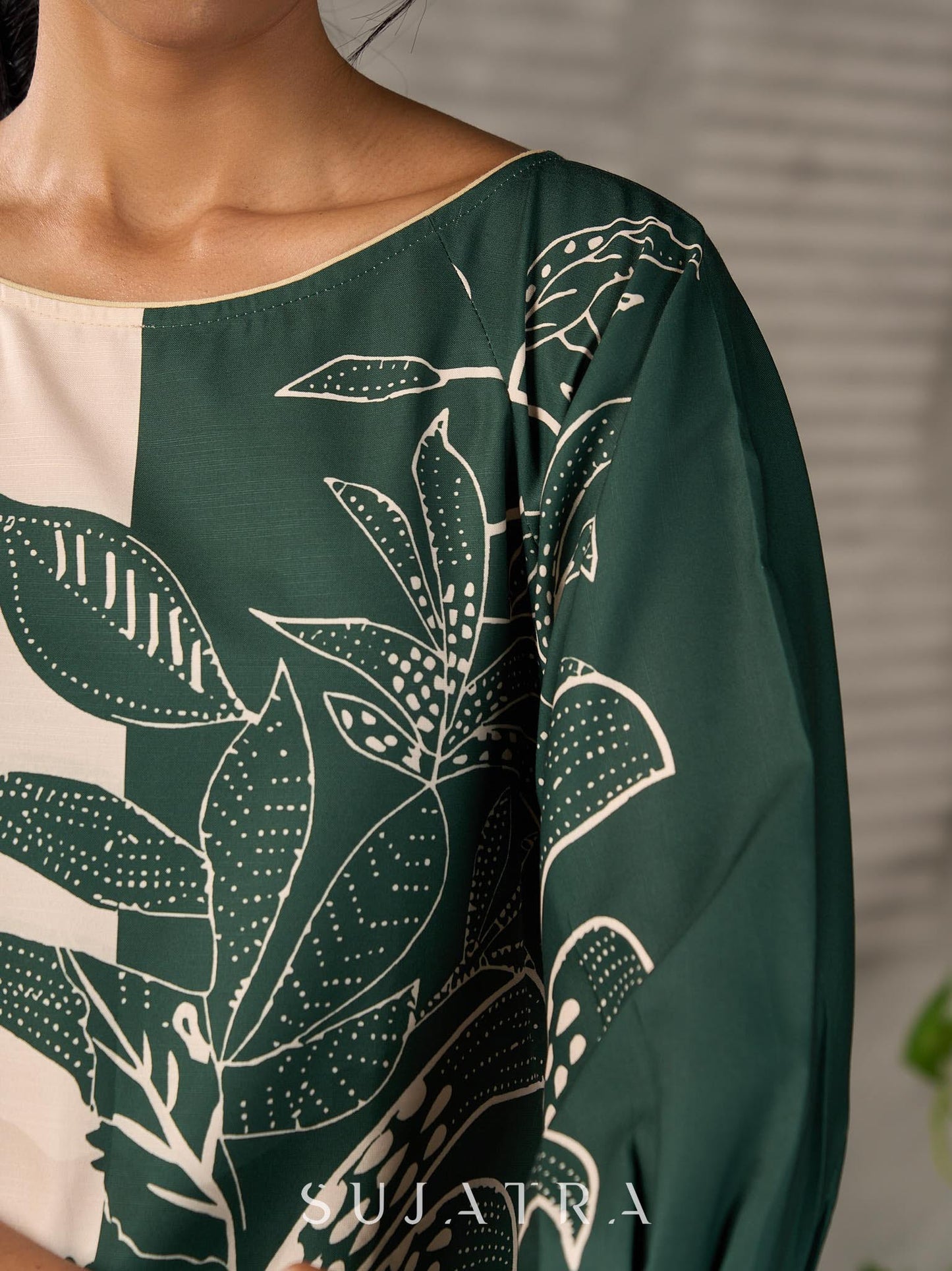 Bottle green and beige half and half dress with raglan sleeves and transitioning floral motifs.