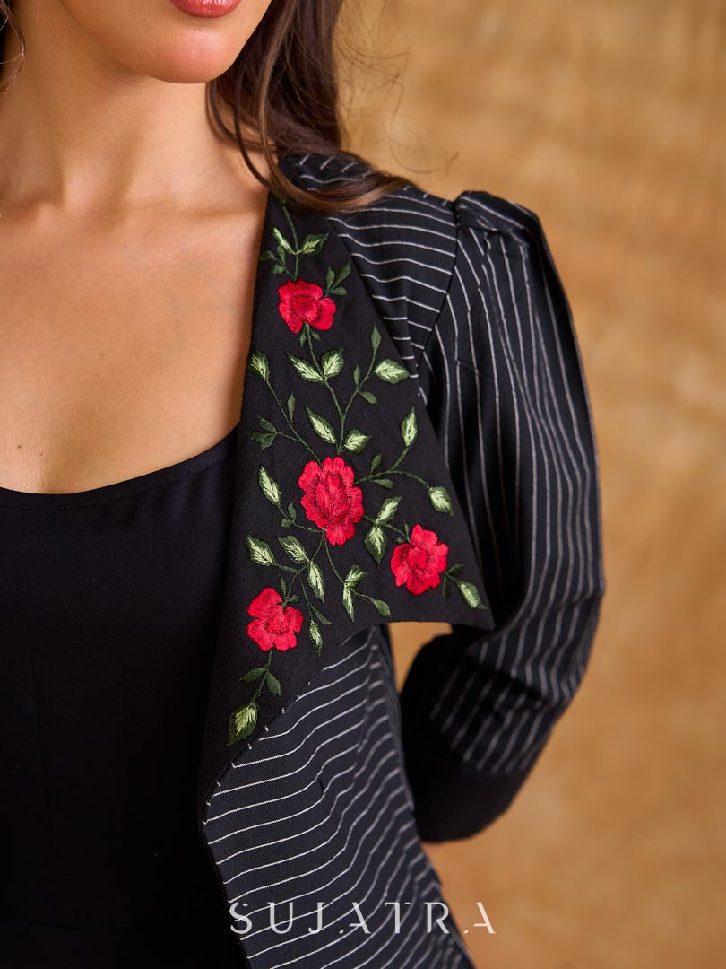 Exquisite black Ikat jacket with offset collar flaps and detailed red floral vine embroidery, delivering a sculpted, high-impact silhouette with refined presence for corporate styling.
