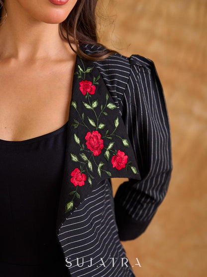 Exquisite black Ikat jacket with offset collar flaps and detailed red floral vine embroidery, delivering a sculpted, high-impact silhouette with refined presence for corporate styling.