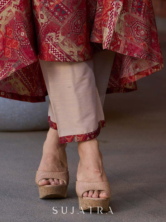 Polished cream silk pants with a striking maroon border accent.
