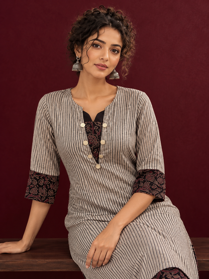 Elegant Beige Ajrakh Striped Cotton Kurta with Contrast Black Floral patch in Neckline & Sleeve Cuffs — seated detail