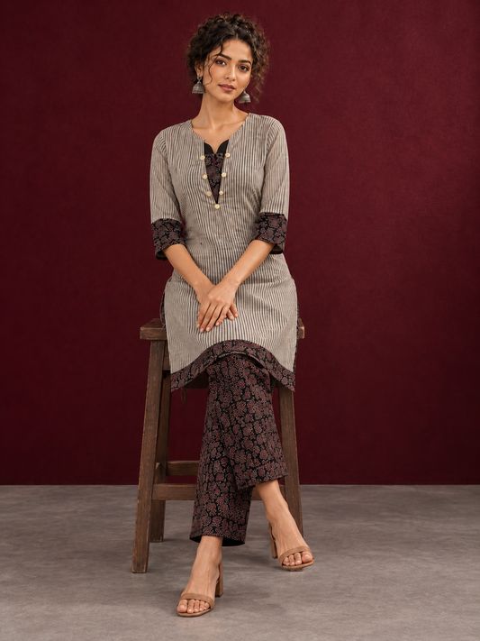 Elegant Beige Ajrakh Striped Cotton Kurta with Contrast Black Floral patch in Neckline & Sleeve Cuffs — seated
