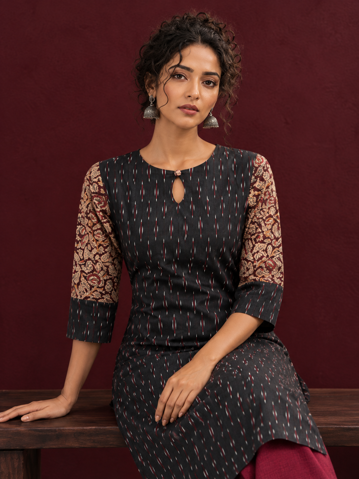 Timeless Black Ikat Cotton Kurta with Contrast Kalamkari Print Sleeves & Keyhole Neckline — seated detail — view 6