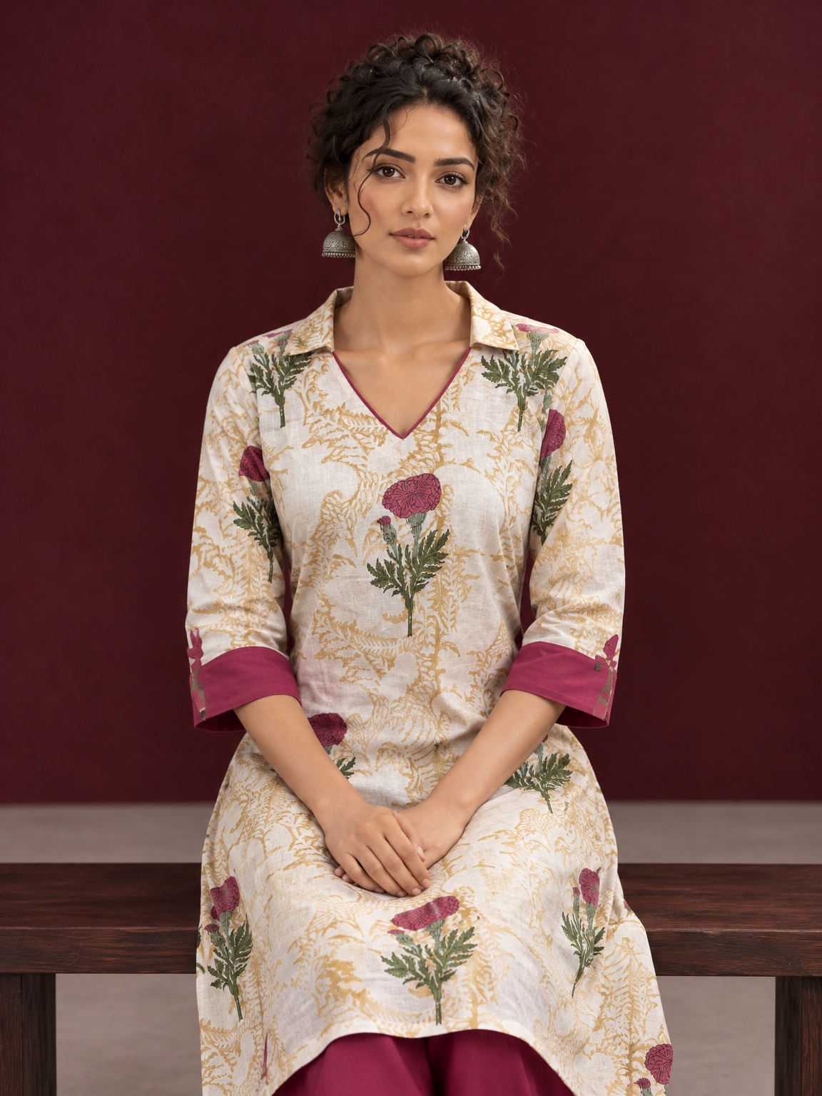 Ivory floral printed kurta with pink and green flowers, a V-neck, and contrasting pink cuffs. — seated detail — view 6
