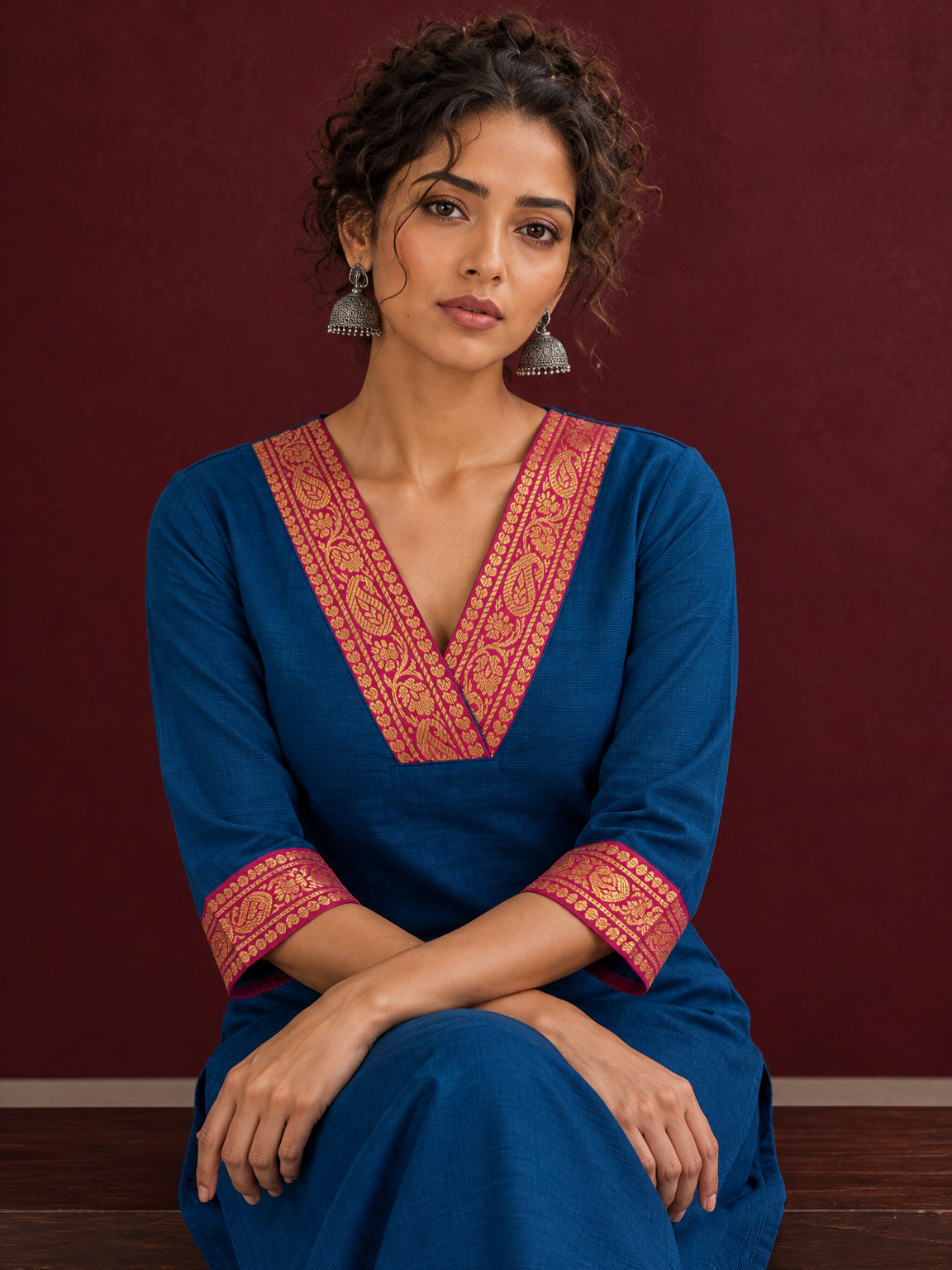 Elegant Peacock Blue Cotton Kurta with Contrast Pink & Gold Woven Border Neckline and Matching Salwar — seated detail — view 5