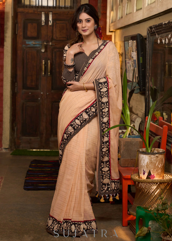 Elegant pastel peach cotton saree highlighted with beautiful floral border