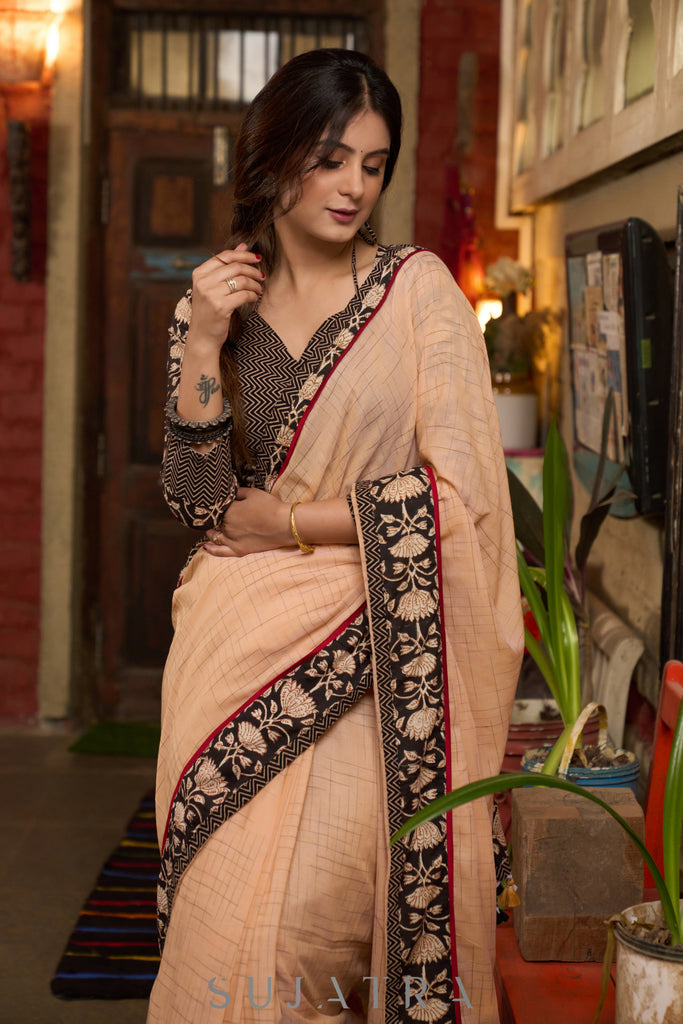 Elegant pastel peach cotton saree highlighted with beautiful floral border