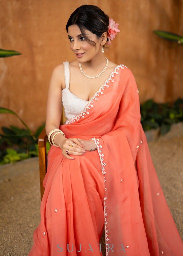 Stylish Apricot Peach Organza Saree Highlighted With Overall Hand Embroidered Pearls