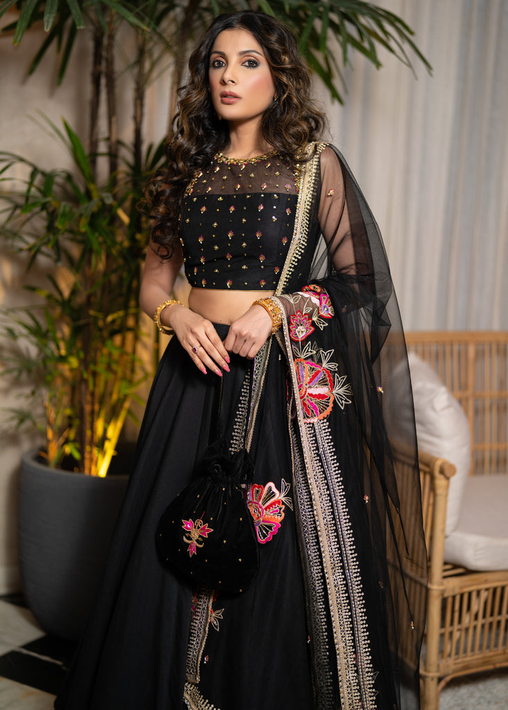 Classic Black Cotton Silk Lehenga paired with delicately embellished net dupatta accentuated with heavy floral embroidery and hand embellishments