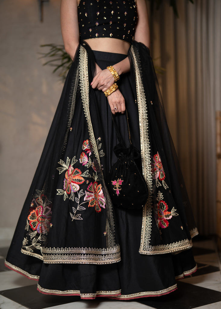 Classic Black Cotton Silk Lehenga paired with delicately embellished net dupatta accentuated with heavy floral embroidery and hand embellishments