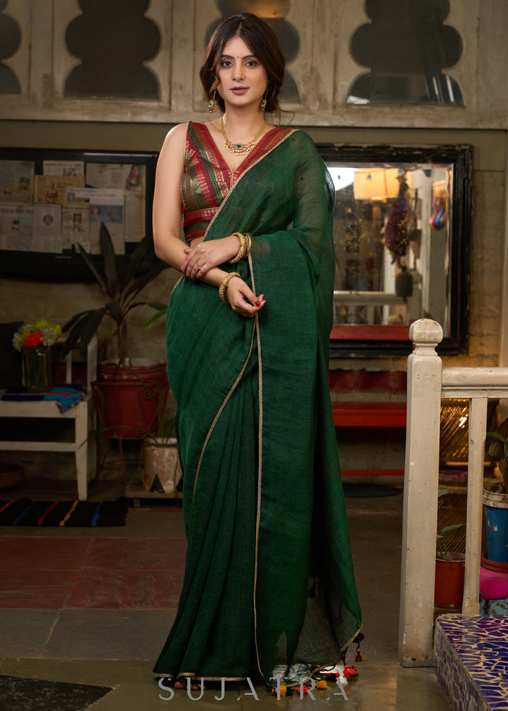 Trendy bottle green cotton saree highlighted with golden lace