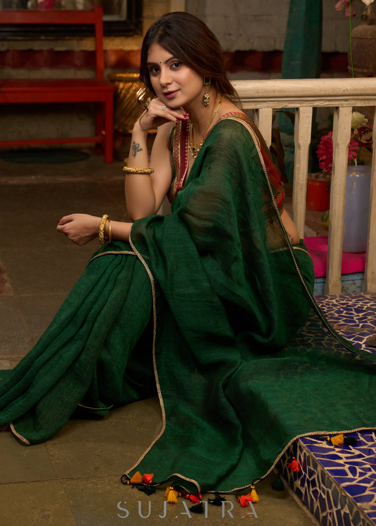 Trendy bottle green cotton saree highlighted with golden lace