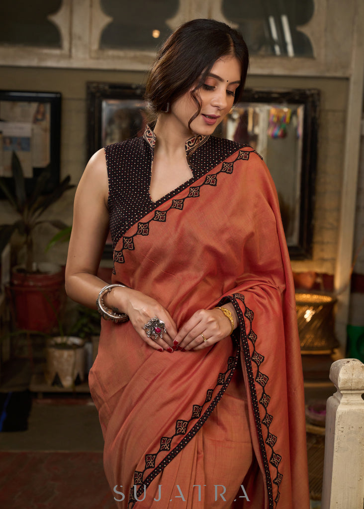 Graceful rust cotton plain saree highlighted with overall ajrakh applique border