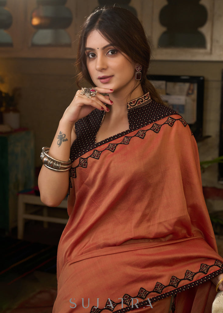 Graceful rust cotton plain saree highlighted with overall ajrakh applique border