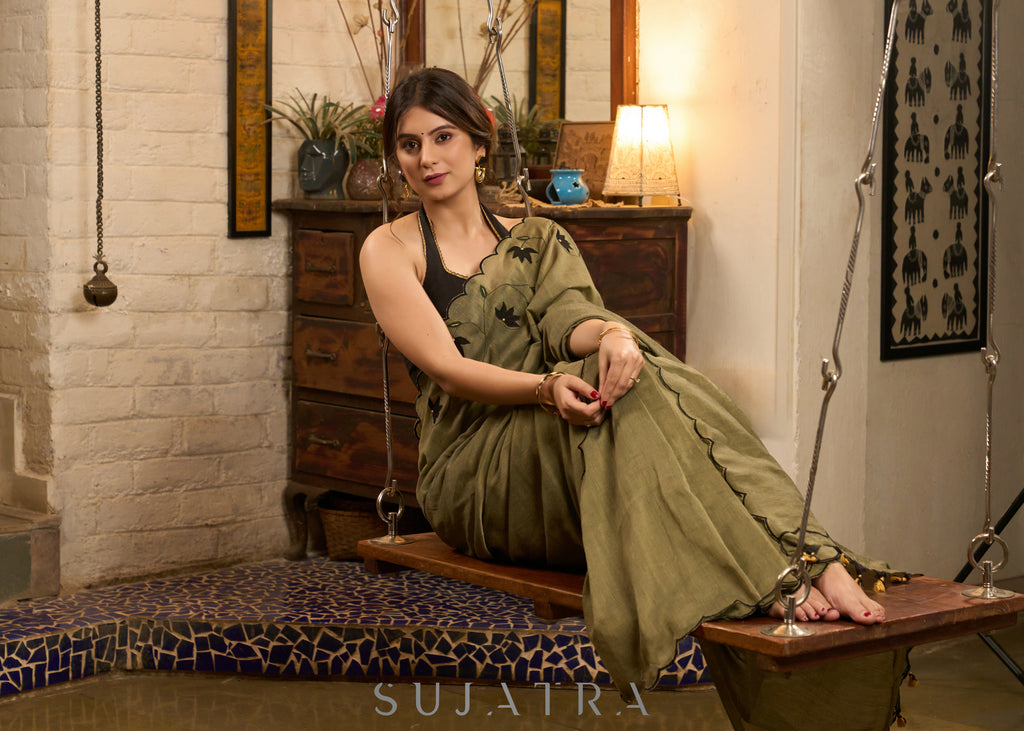 Elegant dark olive green cotton saree highlighted with floral applique and overall scallops