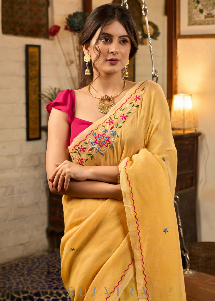 Beautiful yellow cotton saree highlighted with multicolor floral embroidery