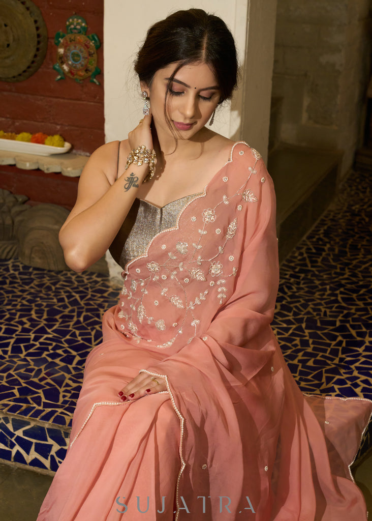 Luscious peach organza saree with beautiful floral hand embroidey and overall scallops