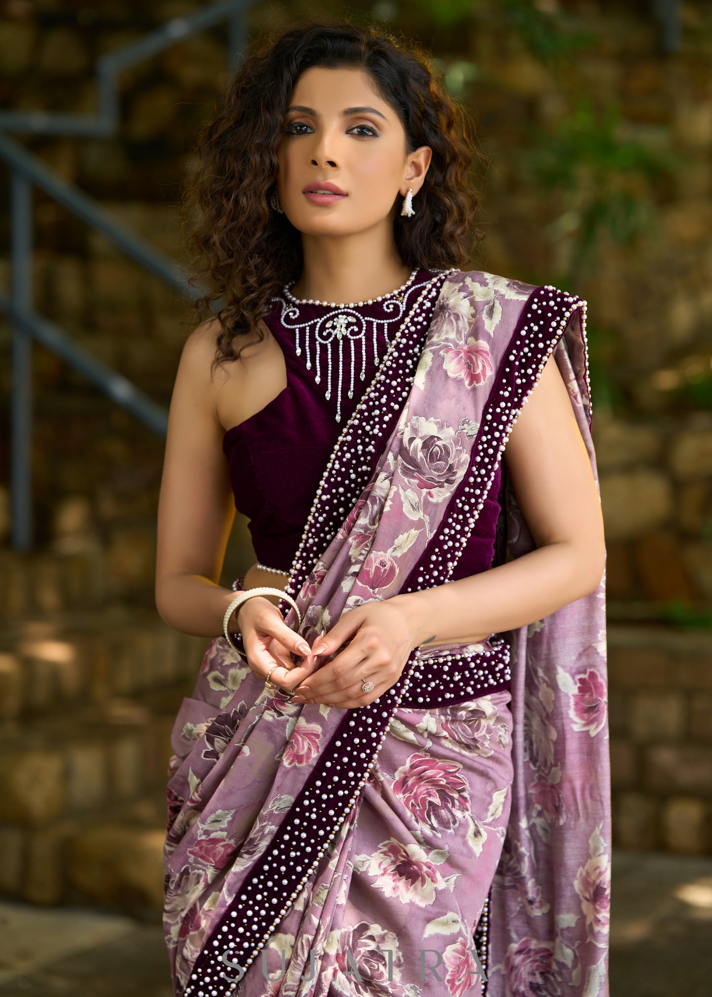 Gracious purple floral printed saree highlighted with velvet pearl embroidered border