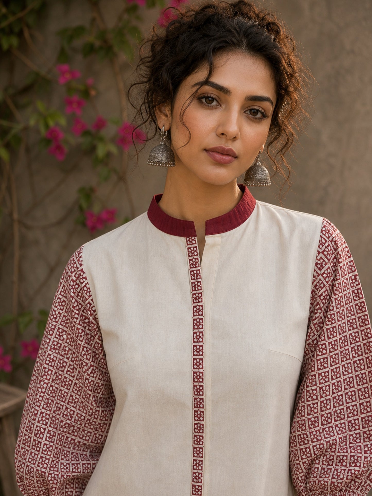 Chic off-white top featuring intricate hand block print sleeves in a vibrant red, complemented by a matching central decorative trim.
