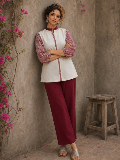 Chic off-white top featuring intricate hand block print sleeves in a vibrant red, complemented by a matching central decorative trim.