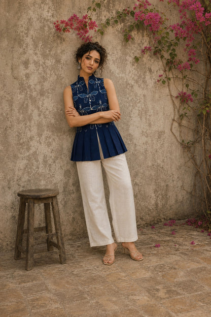 Contemporary indigo top with delicate dragonfly motifs, high folded collar, and graceful pleated hemline.