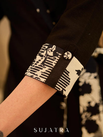 Chic black overlapping blazer-style wrap dress featuring printed black-and-white collar, cuffs, tie detail, and subtle accents