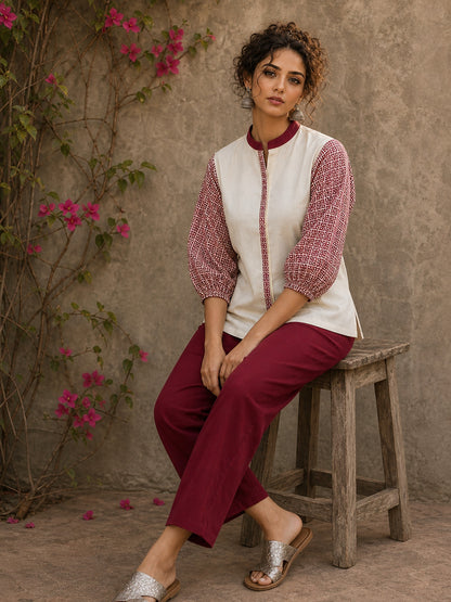 Chic off-white top featuring intricate hand block print sleeves in a vibrant red, complemented by a matching central decorative trim.