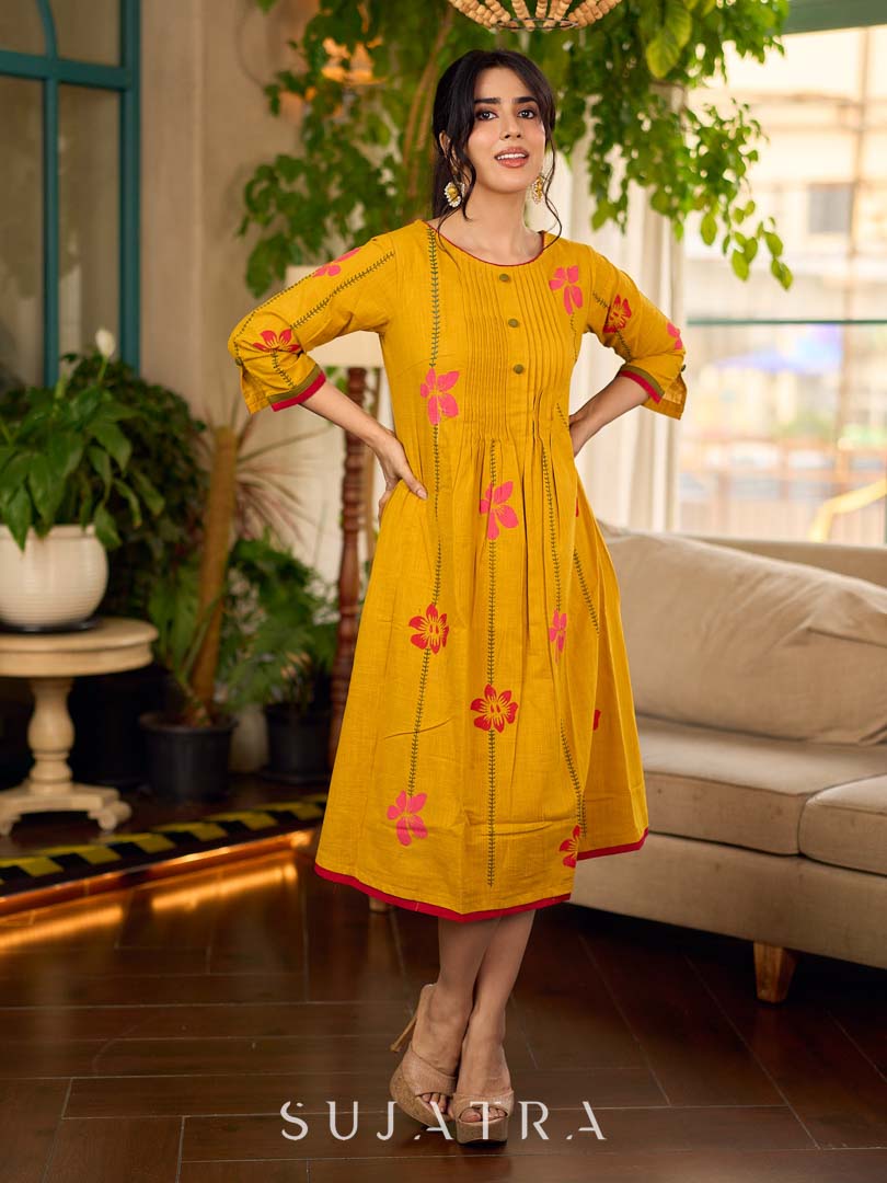 Mustard block printed pintuck dress with hand block red and pink vine floral motifs, accented with red and olive details for a rich, elegant look.