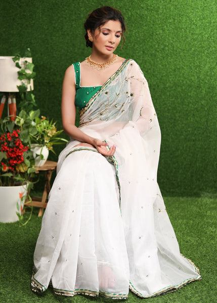 Elegant white saree with delicate hand-embroidery and green Banasari border