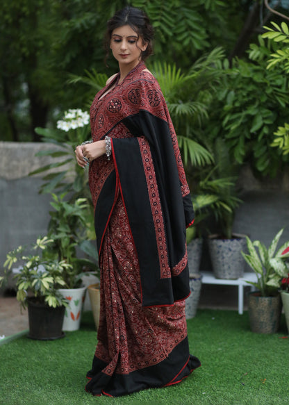 Dussehra Sale — Sensuous maroon Ajrakh saree with black border & Accentuated with stone embellishment.