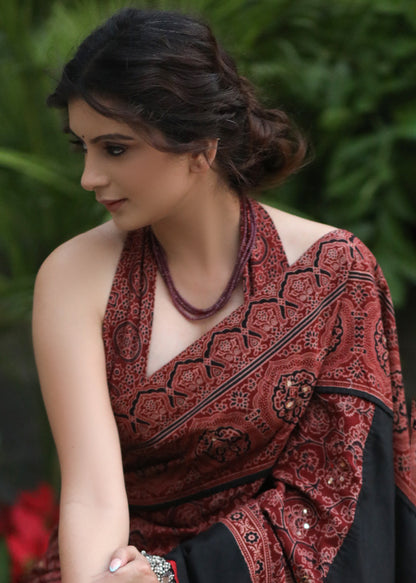 Dussehra Sale — Sensuous maroon Ajrakh saree with black border & Accentuated with stone embellishment.