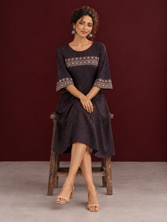 Elegant Black Ajrakh Polka Dot Printed Dress with Maroon Ajrakh Floral Border Yoke and Matching Sleeve Cuffs — seated