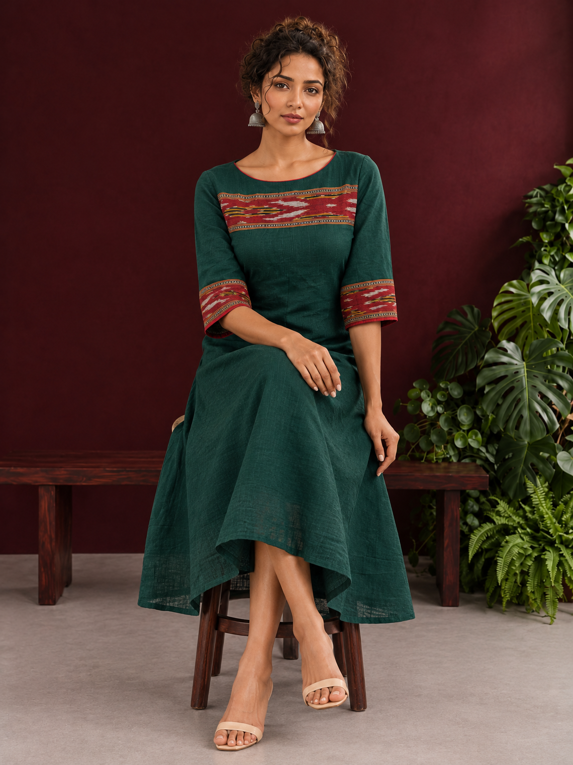 Elegant Bottle Green Cotton Dress with Contrast Maroon Ikat Yoke and Sleeve Border — seated
