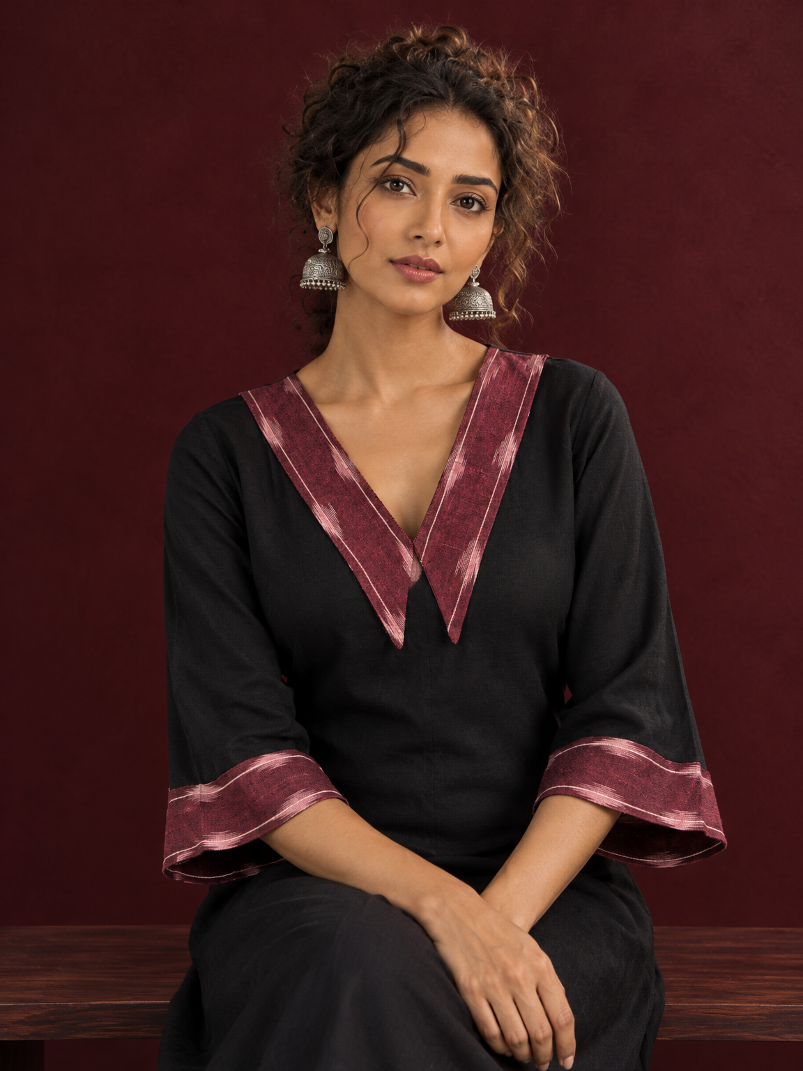Classic Black Cotton A-line Dress with Contrast Maroon Ikat Collar and Matching Sleeve Cuffs — seated detail — view 5