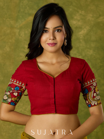 A beautifully hand embroidered maroon blouse paired with artisanal kalamkari.