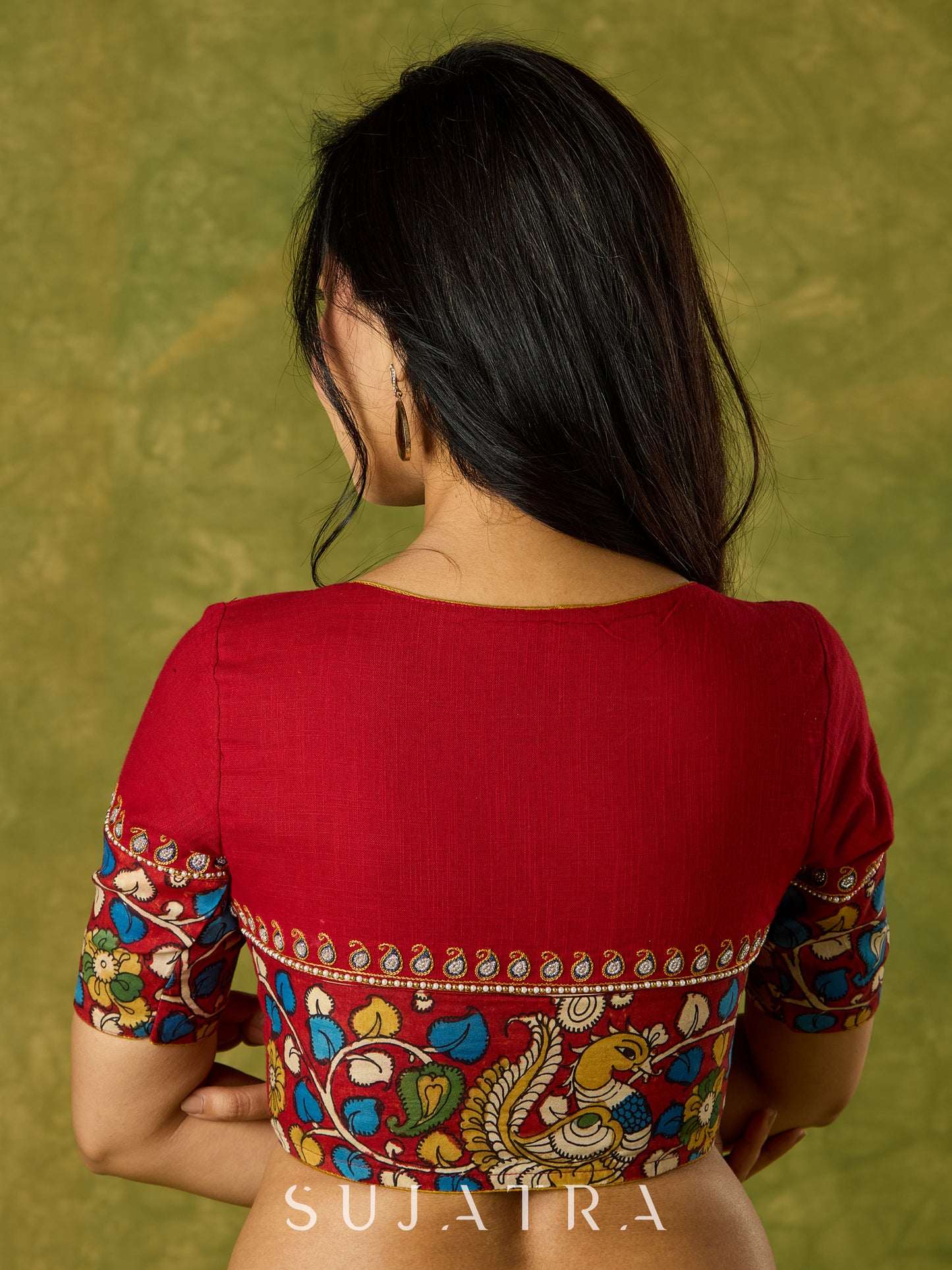 A beautifully hand embroidered maroon blouse paired with artisanal kalamkari.