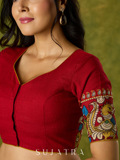 A beautifully hand embroidered maroon blouse paired with artisanal kalamkari.