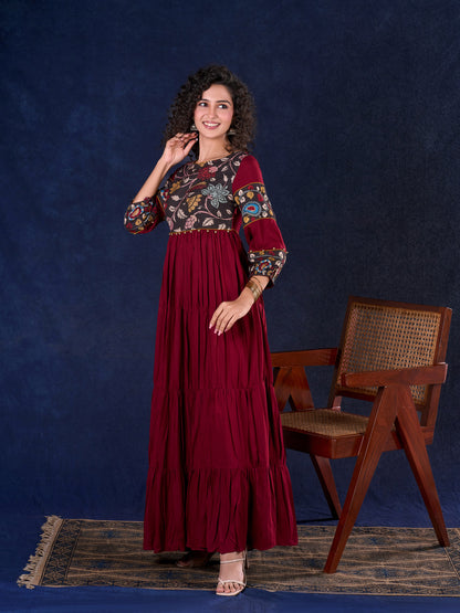 Timeless Maroon Rayon Layered Gown with Gathers and Hand Painted Kalamkari Accents featuring Puffy Sleeves and Delicate Golden Accents