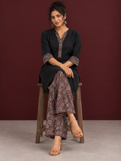 Timeless Black Cotton Tunic with Contrast Ajrakh Print V-Neck Placket & Coordinated Sleeve Cuffs — seated