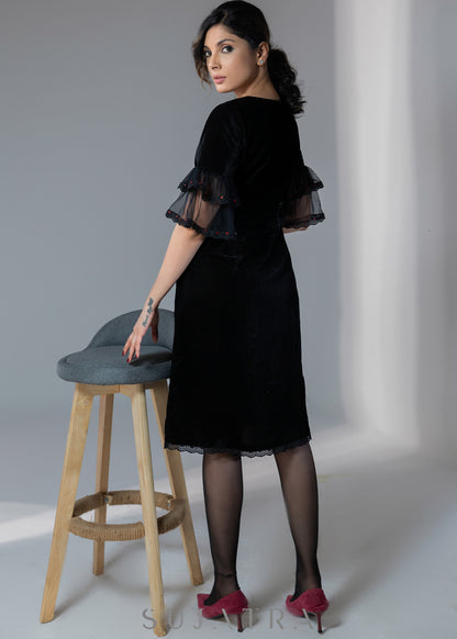 Party wear black velvet dress with net sleeves & red stone work detailing on the neck