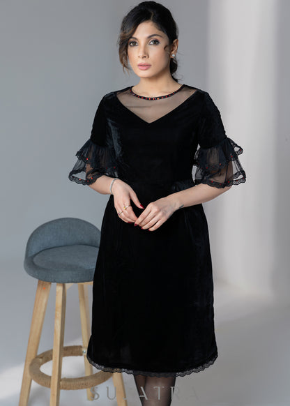 Party wear black velvet dress with net sleeves & red stone work detailing on the neck
