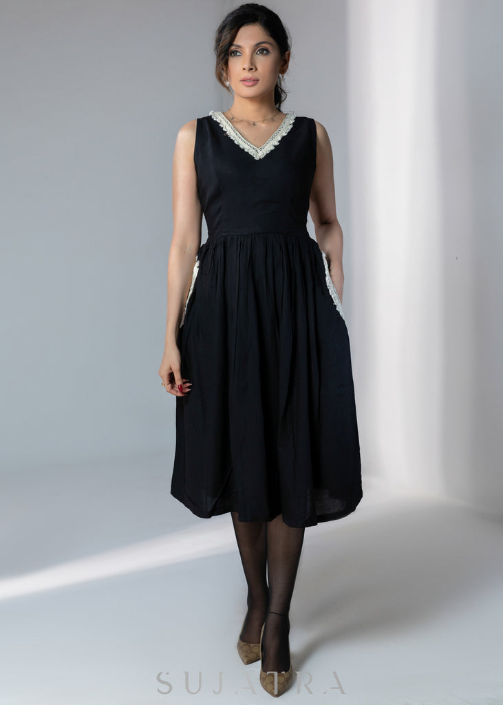 Black sleeveless rayon dress with off white lace detailing on neck and pockets